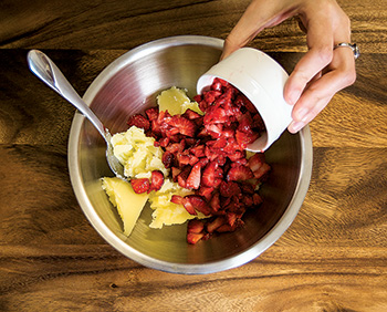 Mix strawberries into cannabutter | Jessica Catalano + Cannabis Now Magazine